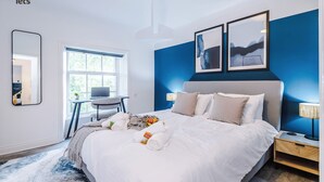 Une chambre d’hôtel avec un grand lit, un bureau, une chaise et une fenêtre.