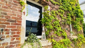 A brick building with a window and a small planter box. - Romantic Suite "Love Room" with Jacuzzi (Sainte-Eusoye)
