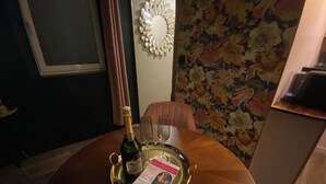 A table with a bottle of champagne, a glass, and a tray with a card. - Romantic Suite "Love Room" with Jacuzzi (Sainte-Eusoye)