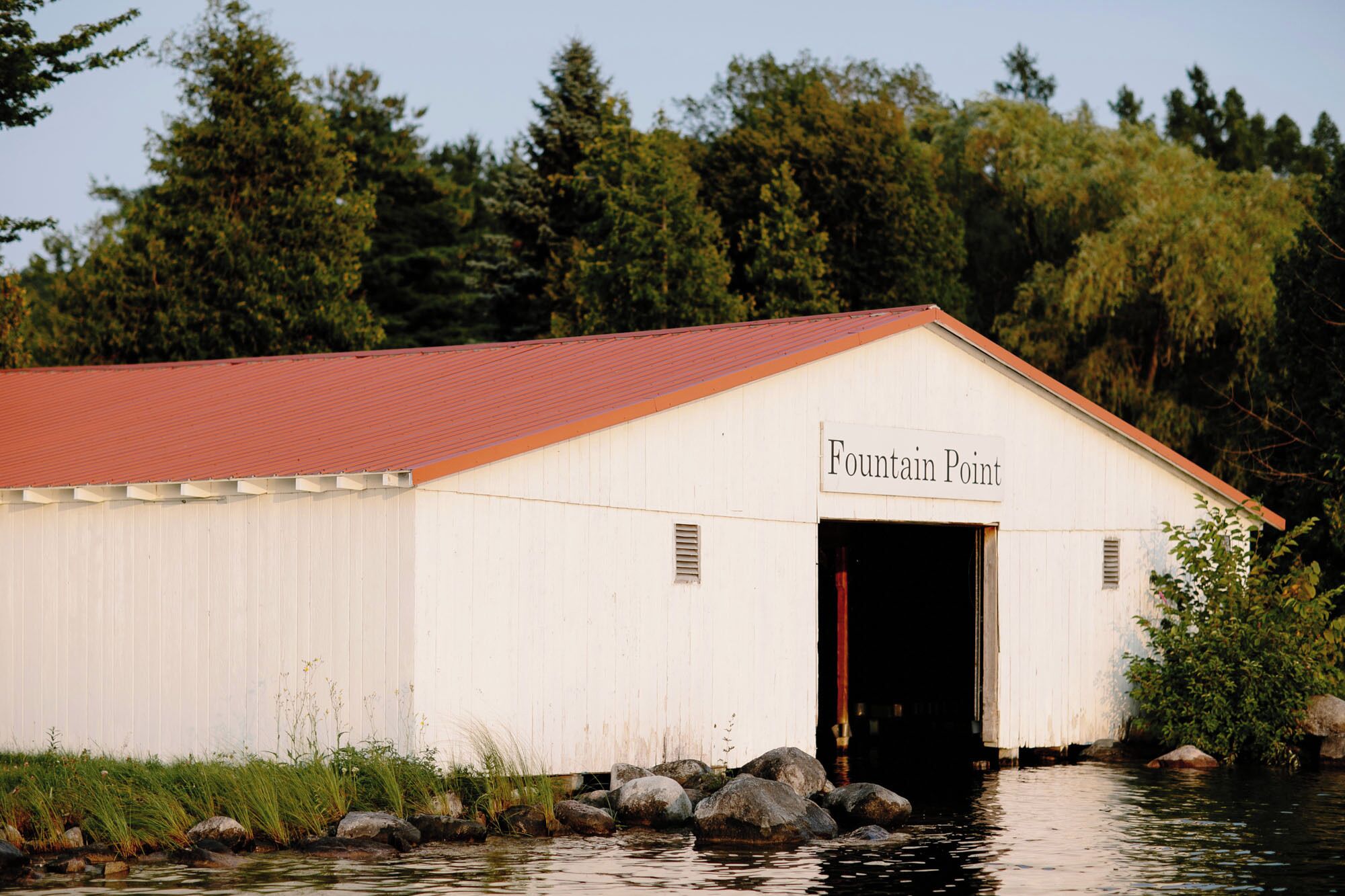 Un edificio blanco con techo rojo identificado como 'Fountain Point'.