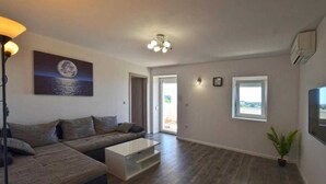 A modern living room with a sofa, coffee table, and a painting of a moon on the wall.