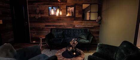A modern living room with a dark green sofa, two armchairs, and a coffee table.