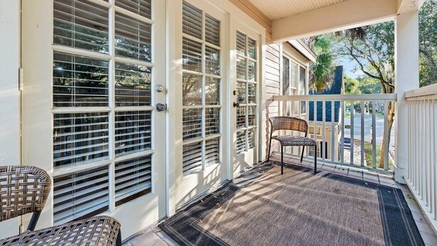 A covered porch with a chair and a doormat. - Gainesville Hideaway (Gainesville)