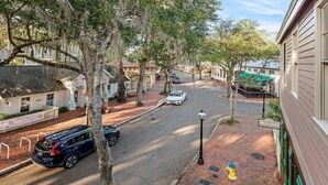 A street view with a white car parked on the side, a yellow fire hydrant, and a building with a sign that reads "Hotel Psychology Wellness Center". - Gainesville Hideaway (Gainesville)