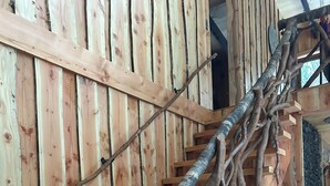 A wooden staircase with a unique design featuring branches integrated into the steps. - House in Huilo Huilo, The Refuge of Fairies and Elves (Neltume)