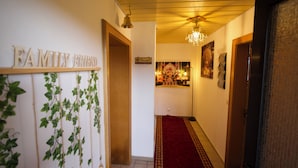 A hallway with a red carpet, wooden doors, and a 'Family Friend' sign. - Stylish and artistic apartment with 400 sqm garden & massage and Ayurveda (Grainet)