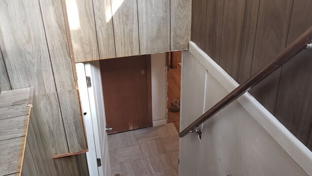 Eine Holztreppe mit Handlauf, die zu einer niedrigeren Ebene führt.