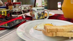 A breakfast setting with a plate of toast, a mug labeled "BEST BOSS," and a pitcher of orange juice. - Kindo Kicha Farmhouse (Moshi)