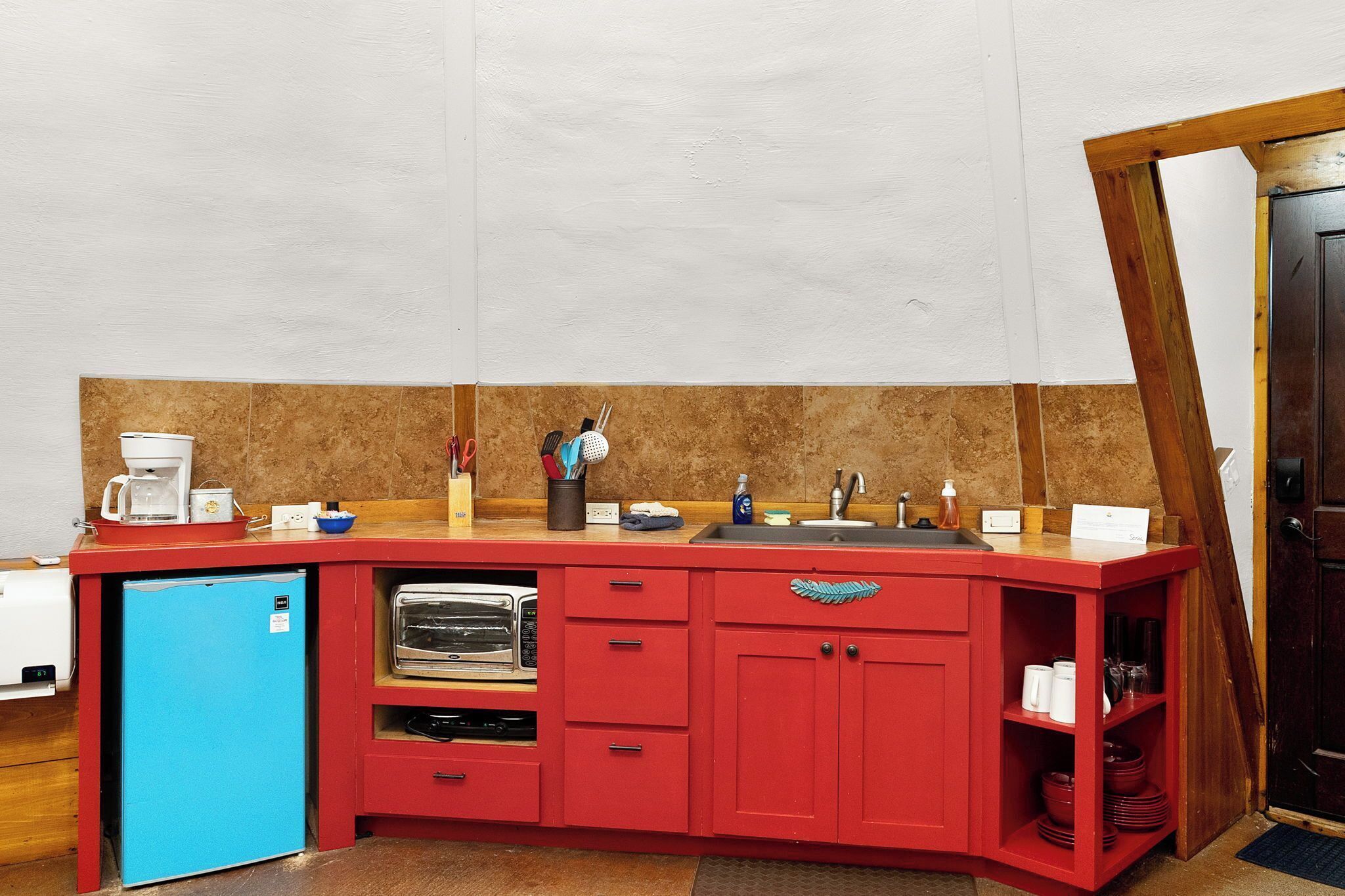 Een oven, een koffiezetapparaat/waterkoker, kookgerei, borden en bestek