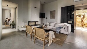 A modern living room with a sofa, two wicker chairs, a coffee table, and a fireplace. - Villa Salina with Pool (Povljana)