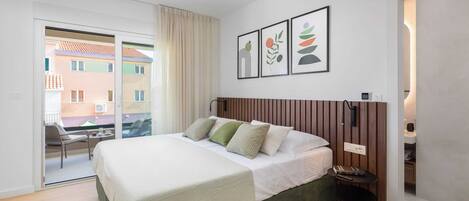 A modern bedroom with a bed, a bedside table, a chair, and a view of the outside.