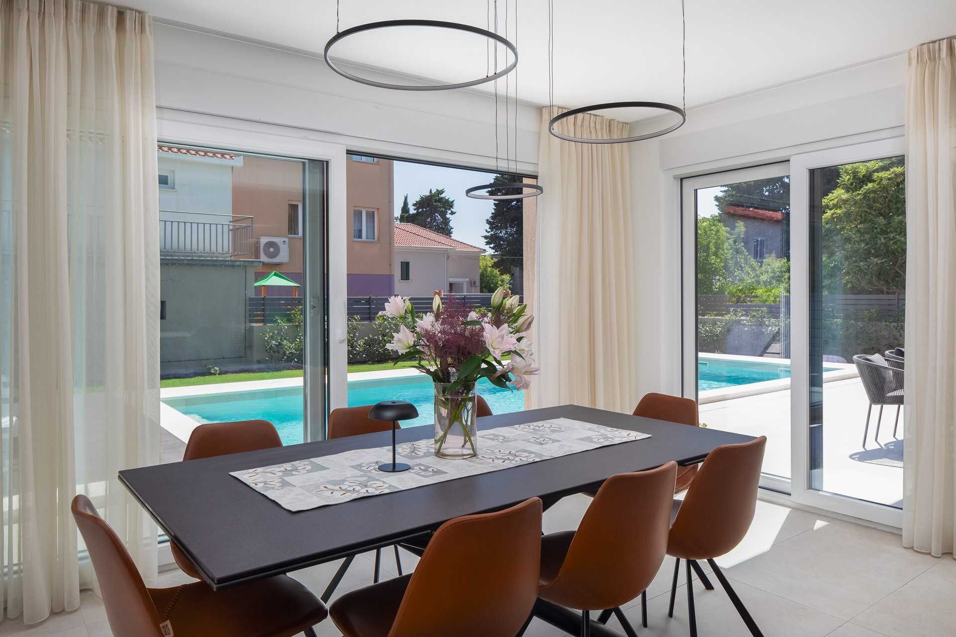 Un coin repas avec une table, des chaises et un vase de fleurs.