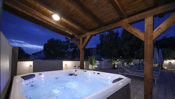 A hot tub under a wooden pergola with a view of the surrounding area. - Villa Aquaterra with pool (Nin)
