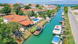 A canal lined with boats and houses with red-tiled roofs. - Villa Aquaterra with pool (Nin)