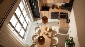 Eine moderne Küche mit Essbereich, großen Fenstern und einer Treppe.