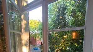 Une pièce dotée d’une grande fenêtre donnant sur un jardin et une rue.