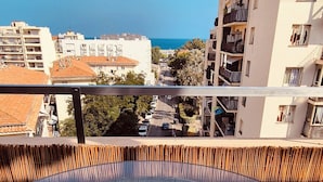 A circular outdoor seating area with a view of a cityscape and the sea.