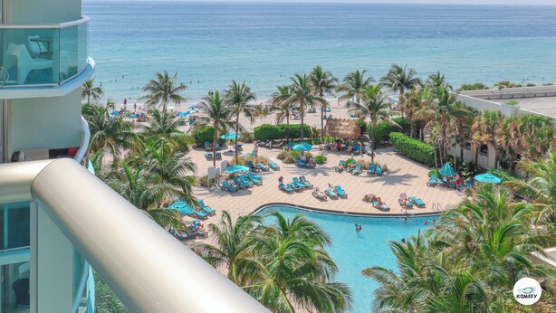 A resort with a pool, beach, and palm trees. - The Tides (Hollywood)
