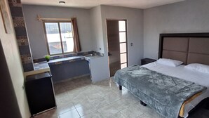 Une chambre à coucher avec un lit, un petit bureau et une fenêtre.