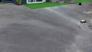 A two-story house with a tiled roof, a front porch with a bench, and a small garden area. - Apartment at the foot of the vineyards with a garden, 10 minutes from Reims (Mailly-Champagne)