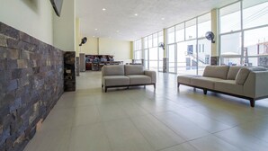A spacious lobby with two sofas, a stone wall, and large windows. - House with Terrace & Pool in Coyula (Tonala)