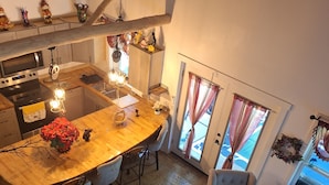 Una cocina moderna con una isla central, piso de madera y una zona de comedor con sofá y sillas.