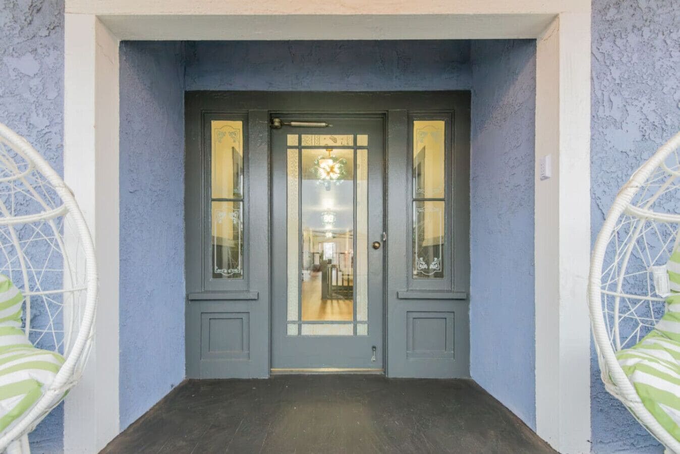 A grey double door with glass panels and a small window above it.