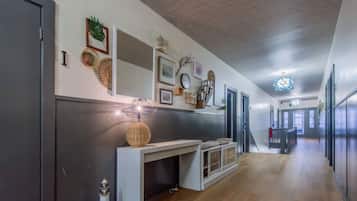 Una cocina moderna con una isla central, suelo de madera y una escalera que lleva a otro nivel.