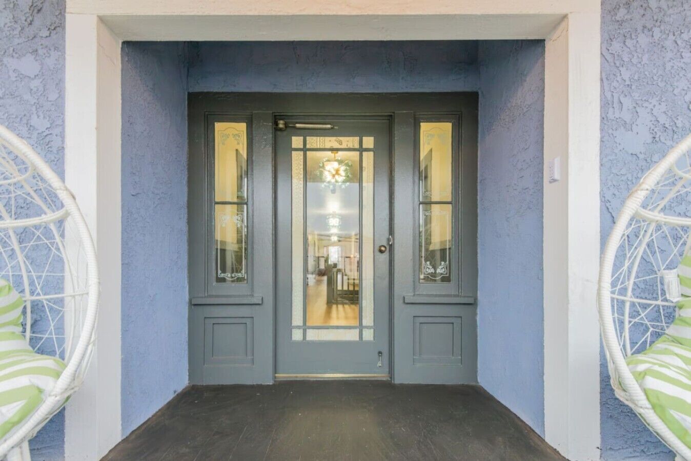 A grey double door with glass panels and a small window above it.