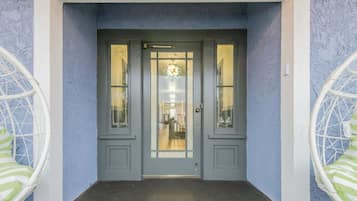 A grey double door with glass panels and a small window above it.