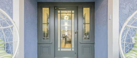 A grey double door with glass panels and a small window above it.