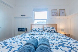 A bedroom with a bed, a window, a nightstand, and a wall-mounted shelf. - Broadway 11 -Clean Cozy Private Studio (Redondo Beach)