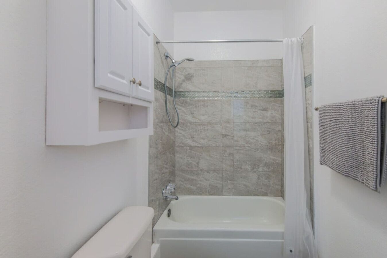 Un baño pequeño y cerrado con bañera, ducha e inodoro.