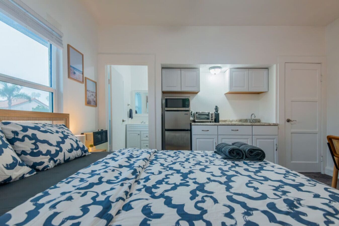 Un dormitorio con cama, mesita de noche y ventana con vistas.