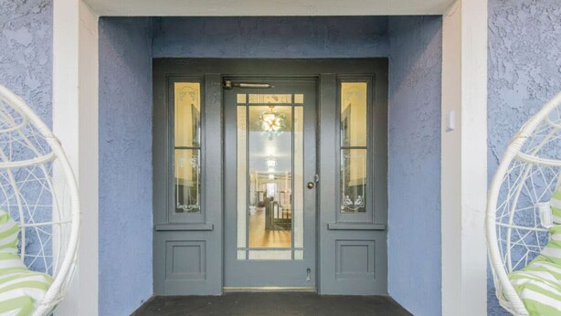 A grey double door with glass panels and a small window above it.