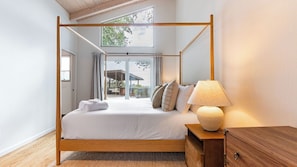 Ein Himmelbett mit Blick auf einen Balkon und Sitzgelegenheiten im Freien.