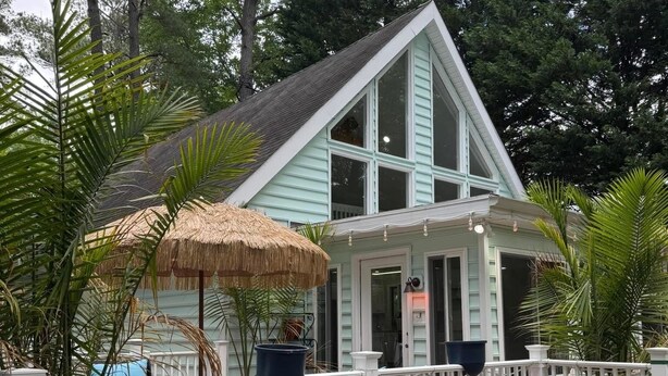 A house with a white fence, a thatched umbrella, and a potted plant. - Cozy, family friendly, home away from home in welcoming Ocean Pines! (Ocean Pines)