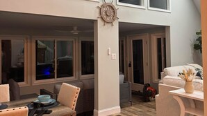 A spacious loft with high ceilings, large windows, and a wooden dining table. - Cozy, family friendly, home away from home in welcoming Ocean Pines! (Ocean Pines)