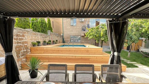 Eine Terrasse im Freien mit Pool, Holzdeck und Sitzbereich.