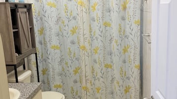 Ein Badezimmer mit Toilette, Waschbecken und Duschvorhang.