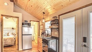 A compact kitchen with a refrigerator, stove, and microwave.