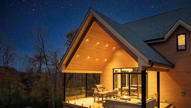 Una casa moderna con una amplia terraza, un jacuzzi y un cielo estrellado.