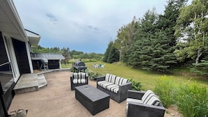 Eine Terrasse im Freien mit Korbmöbeln und einem Grill.