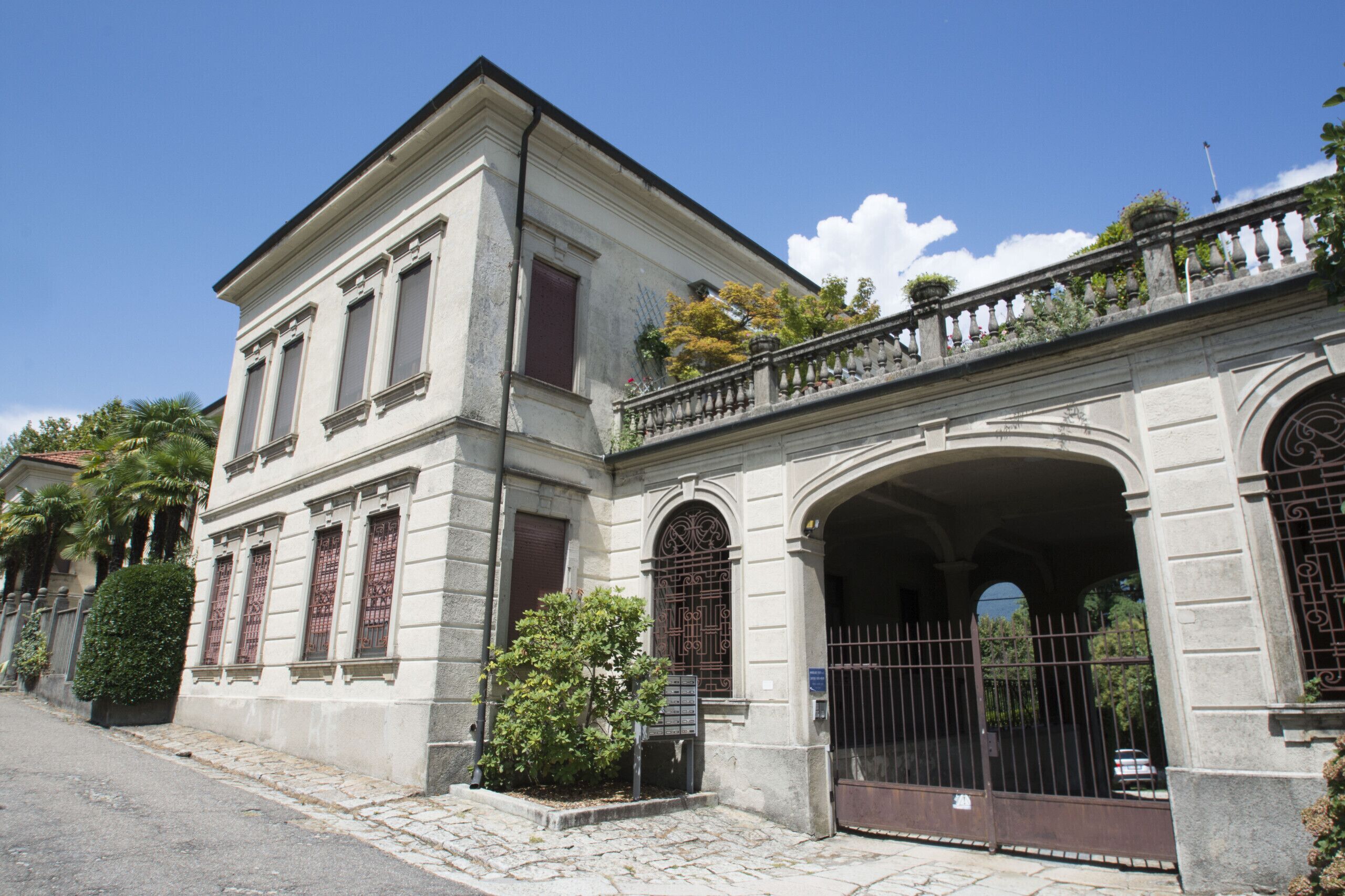 A historic building with a classical facade, large windows, and a gated entrance.