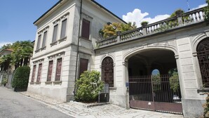 A historic building with a classical facade, large windows, and a gated entrance.