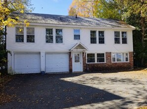 A two-story house with a garage, a front porch, and a driveway.