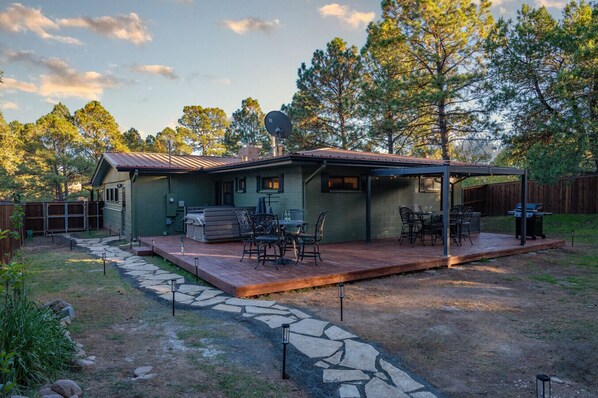 A house with a patio, outdoor seating, and a barbecue area.