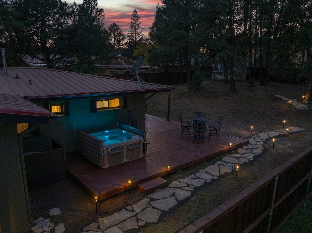 A house with a hot tub, outdoor seating, and a stone pathway.