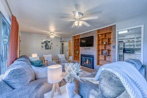 A modern living room with a fireplace, comfortable seating, and a television.