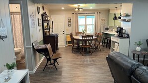 A spacious kitchen with a dining area, wooden flooring, and a modern chandelier. - Windy Hill Farmhouse in Caldwell (Caldwell)